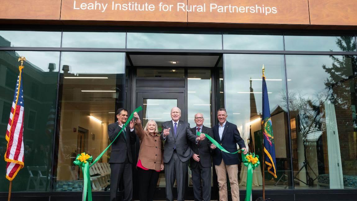5 people excitedly cut a green ribbon in a ceremonial fashion. From left: UVM President Suresh Garimella, Marcelle Leahy, retired U.S. Sen. Patrick Leahy, U.S. Sen. Peter Welch and Vermont Governor Phil Scott. Photo: Andy Duback.