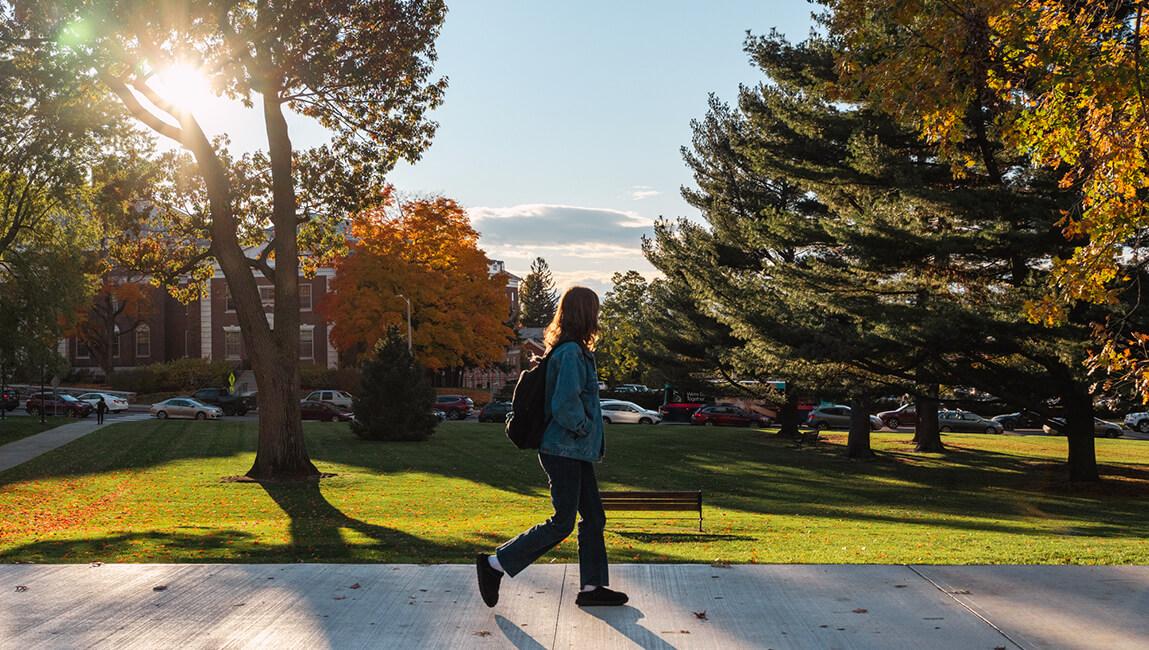 student with back pack walking on campus