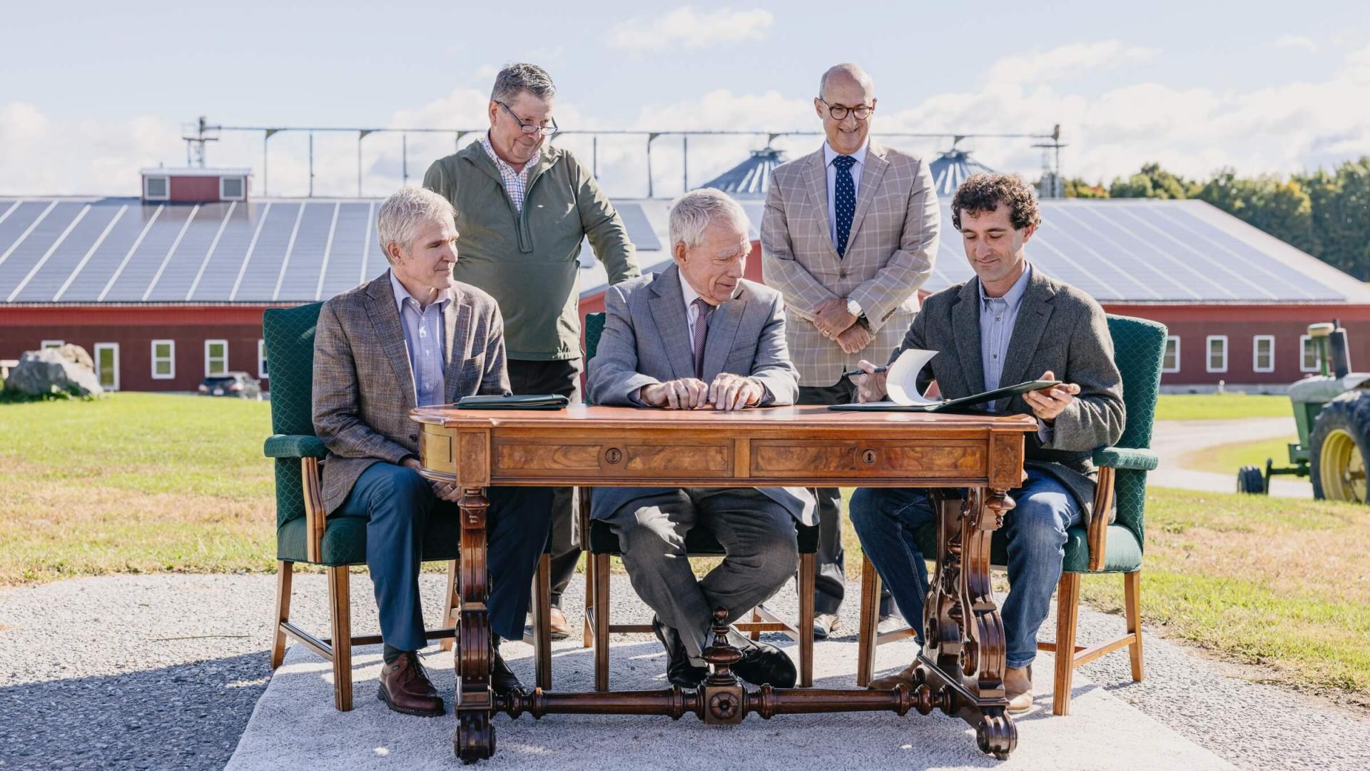 Nordic Farm property co-owner Benjamin Dobson and officials from UVM and the USDA's Agricultural Research Service sign a long-term lease agreement on the antique desk that belonged to Vermont Senator Justin Morrill—author of the Land-Grant College Act of 1862—with Anson Tebbetts, Vermont’s Secretary of Agriculture, Food and Markets. Photo credit: Joshua Defibaugh, UVM.