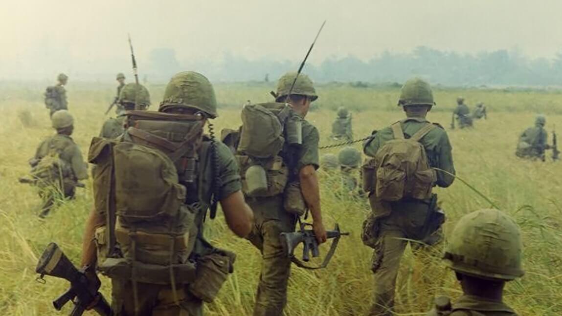 U.S. soldiers crossing a field in Vietnam during the war