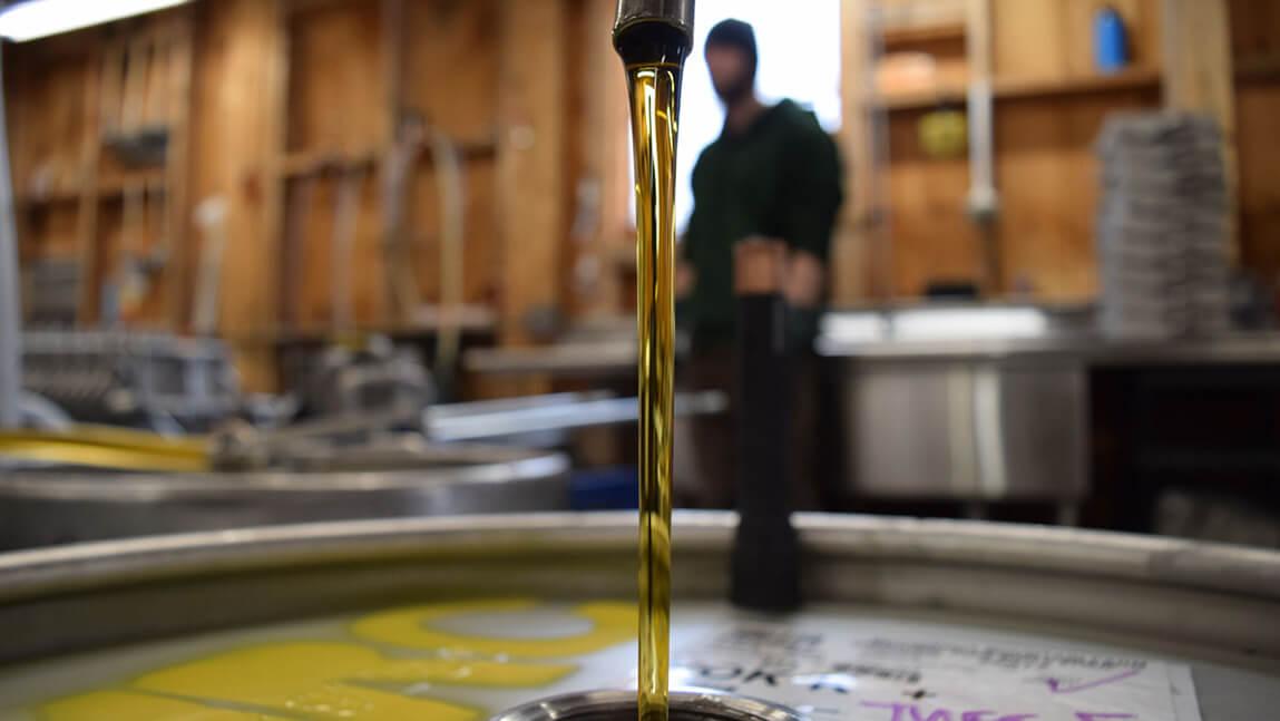 maple syrup pouring into a vat