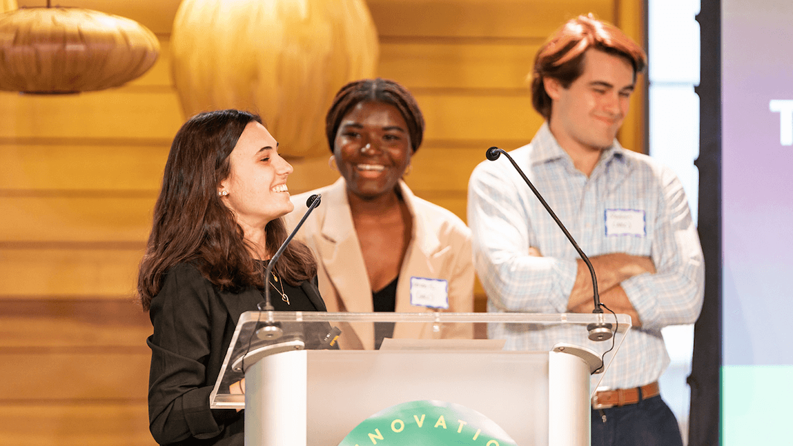 Three students standing at a podium